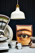 Kitchen scales, mug and framed picture of eye on kitchen worktop