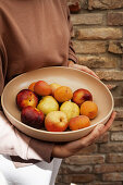 Woman holding bowl of fruit in hands