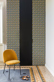Yellow chair in front of wardrobe with doors covered in black and white fabric
