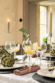 Festively laid table with artichokes as decoration and cocktail