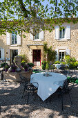Terrace with table, chairs and fountain outside Provençal country house
