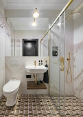 Kleines Badezimmer mit gemusterten Bodenfliesen, Marmorwand und verglaster Duschkabine