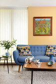 Blue upholstered sofa, side table, and coffee table in the seating area