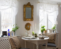 Easter table set for two, above it mirror with gold frame on the wall