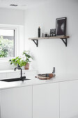 White peninsula kitchen cabinets with an integrated sink