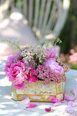 Flowering peonies and historic shrub peonies in nostalgic tin cans