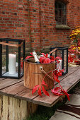 Champagne bucket decorated with red Virginia creeper on wooden table