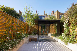 Sunny courtyard garden with modern summer house