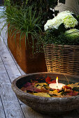 Water bowl with leaves and floating candle on the terrace