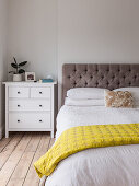 Double bed with capitone headboard and nightstand in bedroom