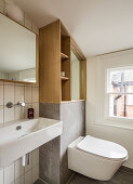 Built in wall shelving unit with toilet and wooden shelf in the bathroom