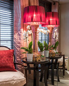 Oversized illuminated lamp and orchid on a side table