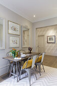 Wooden dining table with vintage metal chairs in bright room