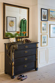 Antique black bureau with gold accents, with a custom wall mirror above it