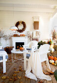 Cozy, autumnal veranda with white chairs