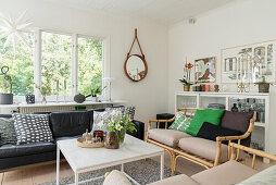 Sitzbereich mit Sofas aus Rattan und aus Leder in offenem Wohnraum