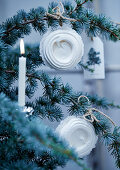White meringue nests and candle on Christmas tree