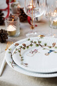Christmas place setting with glasses and lanterns on table