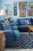 Blaue Sofas mit Denim-Bezug und Bildergalerie im Wohnzimmer mit hellblauen Wänden