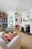 Weiß gestrichenes Wohnzimmer mit Kaminofen und Bücherregal