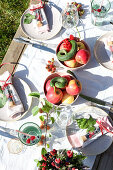 Gedeckter Sommertisch mit Äpfeln im Freien