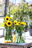Sonnenblumen mit Mohnkapseln, Zieräpfeln, grünen Hortensien und Japanknöterichstäben