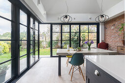 Custom concrete table with classic chairs in front of wrap around floor ceiling windows