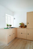 A fitted kitchen with a wooden corner cupboard