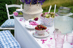 Summer table setting with strawberries, salad and delphinium