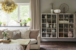 Vintage glass cabinets, in the foreground sofa in the living room in natural colors