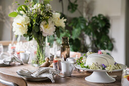 Set table with festive cake and bouquet of flowers