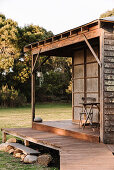 Holzhütte mit Terrasse, beides größtenteils aus recycelten Materialien