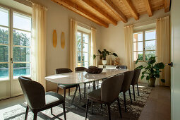 A light-flooded dining room with leather chairs in front of a patio door