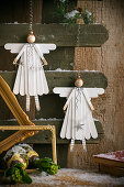Hanging wooden angel decoration on a rustic wall