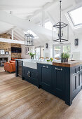 Kitchen island with sink, glass pendant light above in open living area