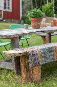 DIY-Sitzbank aus alten Baumstümpfen und Brett am Holztisch