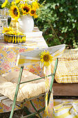 Chair decoration with sunflower blossom and yellow chequered ribbon