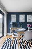 Dining area with black and white striped carpet in front of a blue wall