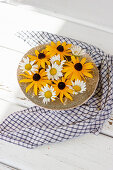 Bowl with flowers of Black-eyed Susan and daisies