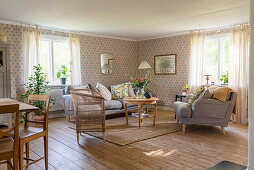 Living room with grey, comfortable living room set, wooden floorboards and wallpapered walls