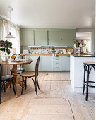 Kitchen-dining room with wooden table, kitchen in mint green