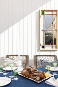 Table with blue tablecloth on wooden terrace