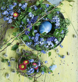Old baking dish with wreath of forget-me-nots and birch twigs, with Easter egg, bouquet of bellis