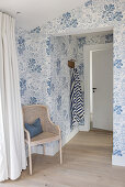 Sitting area in the bedroom with blue and white wallpaper