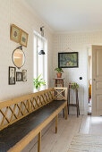 Long wooden bench in the hallway with wallpaper, photos and pictures