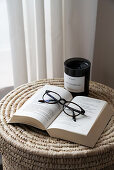 Book with glasses on wicker container