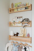 Shelves with toys, books and baby clothes on the wall