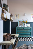 Turquoise blue chest of drawers and disused fireplace with chest and mantelpiece in the living room
