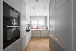 Moderne graue Küche mit Steinarbeitsplatte und geriffelten Schrankfronten