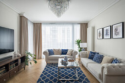 Wohnzimmer im Hampton-Stil, hellgraue Sofagarnitur und blaue Accessoires